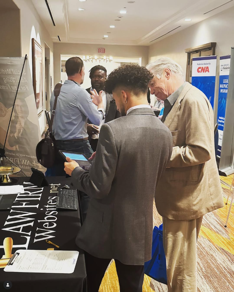 An LFW team member sharing a tablet demonstration with an attendee at the event booth.